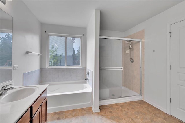 bathroom featuring vanity and independent shower and bath