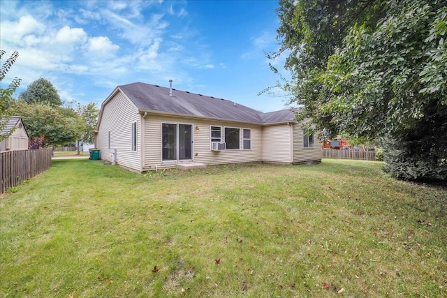 back of house with cooling unit and a yard