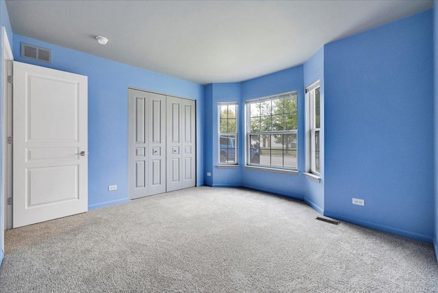 unfurnished bedroom featuring carpet and a closet