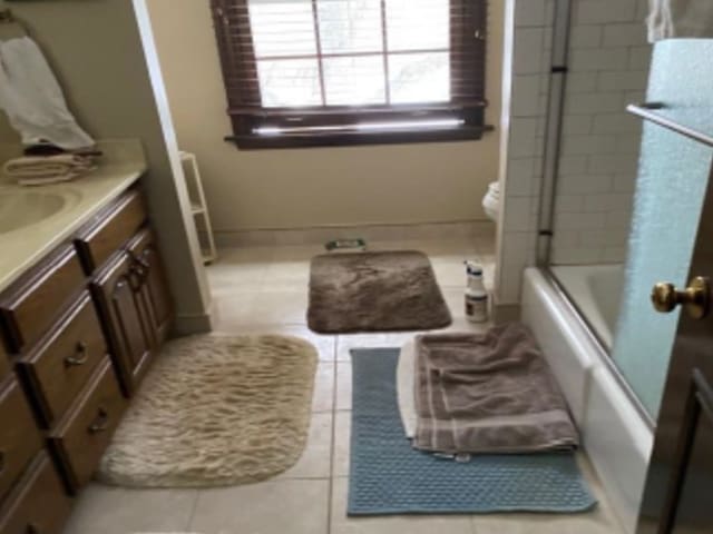 bathroom with vanity, shower / bath combination with glass door, and tile patterned flooring