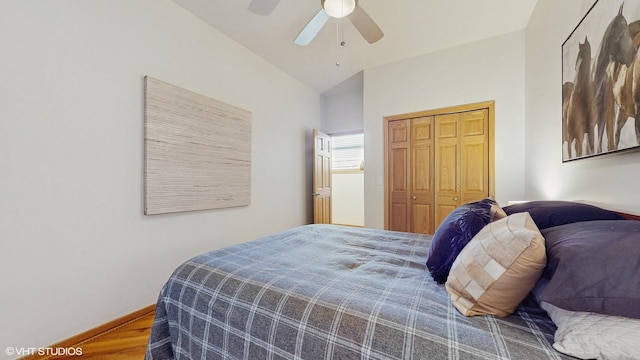 bedroom featuring lofted ceiling, a closet, a ceiling fan, wood finished floors, and baseboards