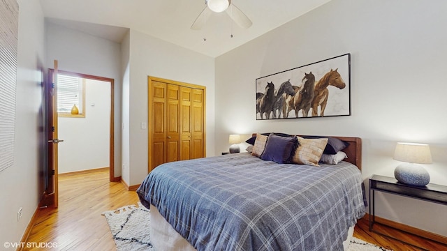 bedroom with light wood-style floors, ceiling fan, baseboards, and a closet