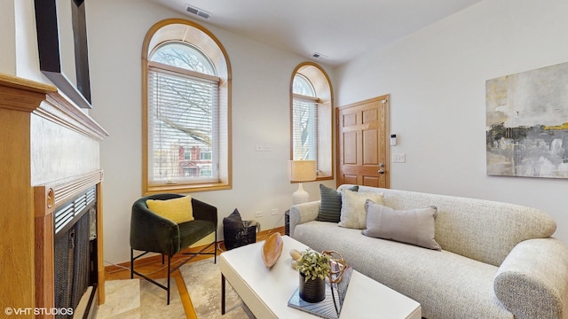 living room featuring visible vents and a tiled fireplace