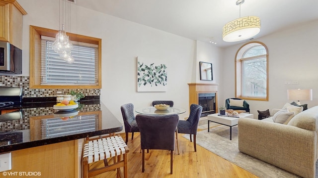 dining space with light wood-type flooring and a fireplace