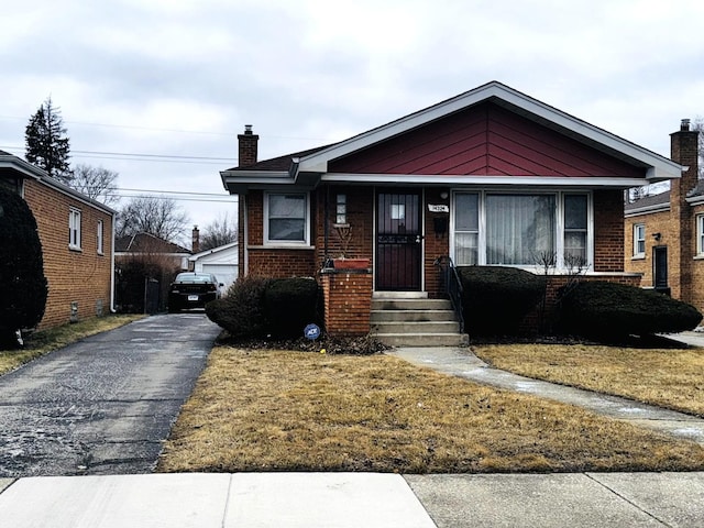 bungalow-style home with a front yard