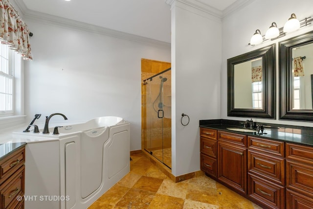 full bathroom featuring a stall shower, ornamental molding, washing machine and clothes dryer, vanity, and a bath