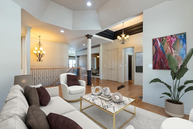 living room with a chandelier, wood finished floors, and decorative columns