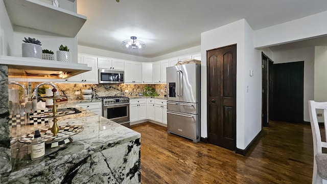 kitchen featuring tasteful backsplash, white cabinetry, high end appliances, light stone countertops, and dark wood-type flooring