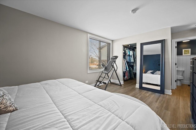 bedroom with hardwood / wood-style floors, a walk in closet, a closet, and ensuite bathroom