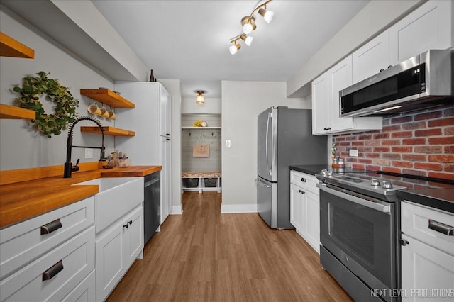 kitchen featuring white cabinetry, stainless steel appliances, sink, and light wood-type flooring