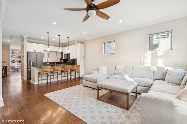 living room featuring ornamental molding, ceiling fan, and dark hardwood / wood-style flooring