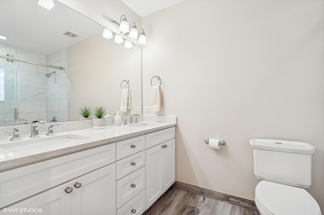 bathroom featuring an enclosed shower, vanity, hardwood / wood-style flooring, and toilet