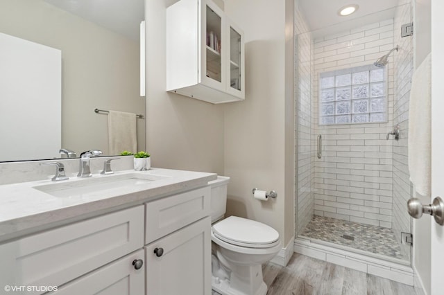 bathroom with vanity, wood-type flooring, toilet, and walk in shower