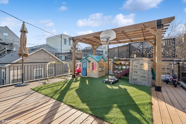 wooden terrace featuring a lawn and a playground