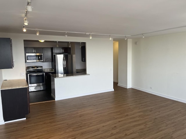 kitchen featuring dark hardwood / wood-style flooring, track lighting, and stainless steel appliances