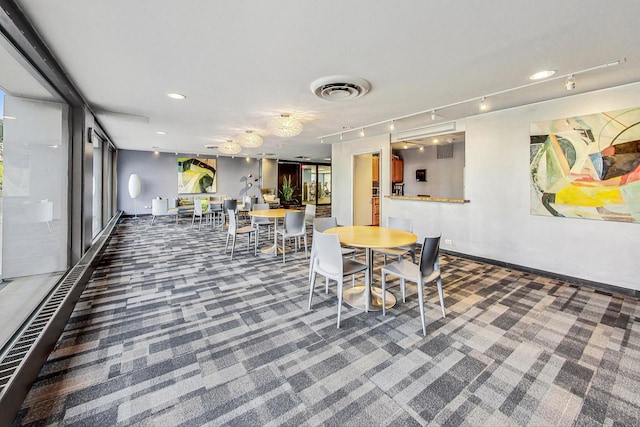 dining room with track lighting and dark colored carpet