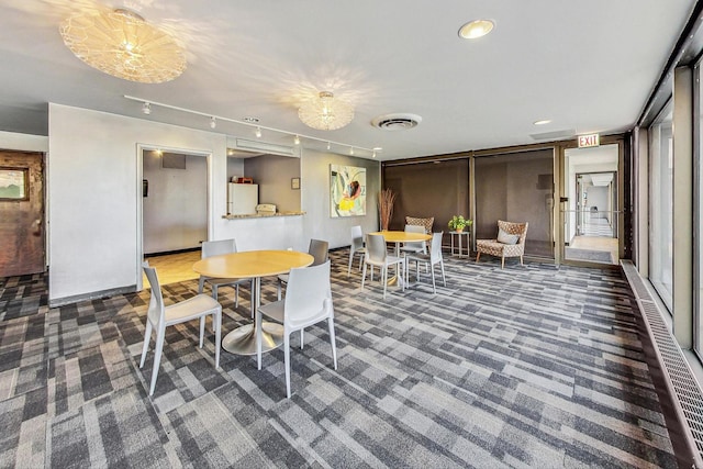 carpeted dining room featuring rail lighting