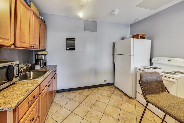 kitchen with light stone counters, sink, white appliances, and light tile patterned floors