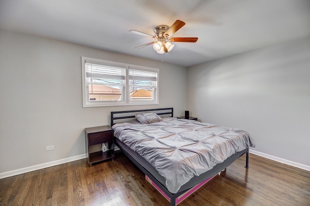 bedroom featuring a ceiling fan, baseboards, and wood finished floors