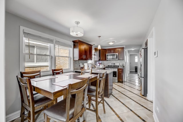 dining room with light tile patterned flooring and baseboards