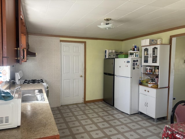 kitchen featuring ventilation hood, crown molding, and white appliances