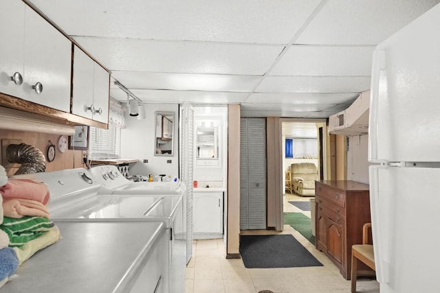 laundry room with separate washer and dryer and cabinets