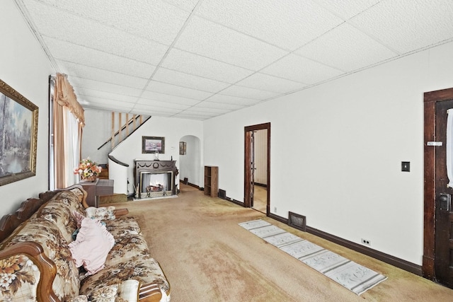 unfurnished living room featuring a drop ceiling and carpet floors