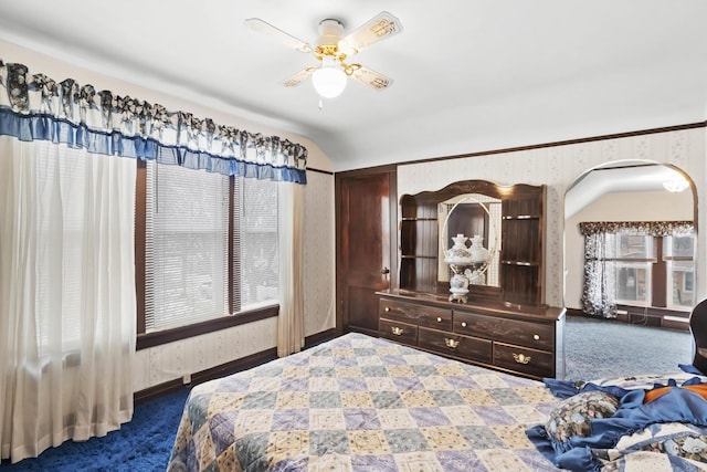 bedroom with ceiling fan, lofted ceiling, and dark carpet