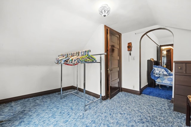 interior space with lofted ceiling and dark colored carpet