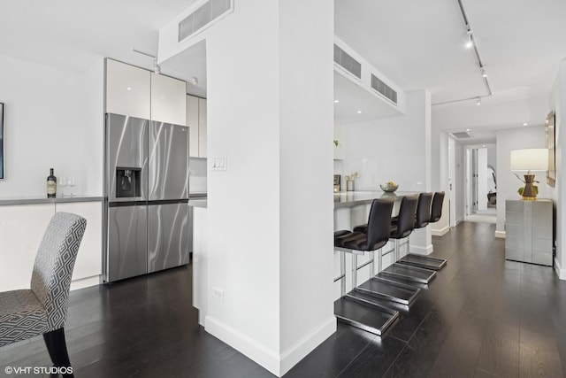 kitchen with visible vents, stainless steel fridge with ice dispenser, dark wood-style floors, modern cabinets, and white cabinetry