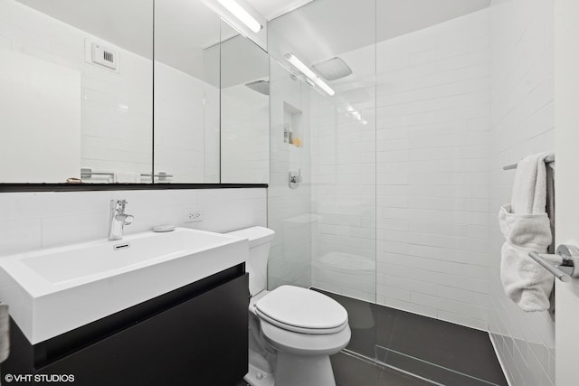 bathroom with vanity, tile walls, toilet, and walk in shower