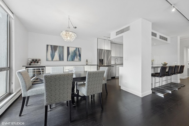 dining room with an inviting chandelier, a baseboard radiator, visible vents, and dark wood finished floors