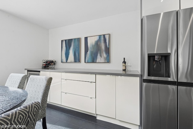 kitchen with white cabinetry, stainless steel fridge with ice dispenser, and modern cabinets