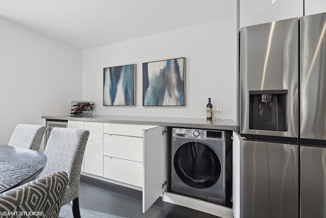 laundry room with washer / clothes dryer, dark tile patterned floors, and laundry area