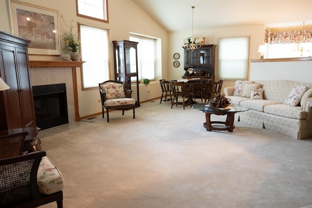 carpeted living room featuring a tile fireplace, high vaulted ceiling, and an inviting chandelier