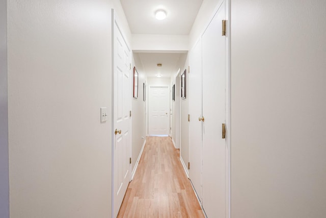 corridor with light hardwood / wood-style floors