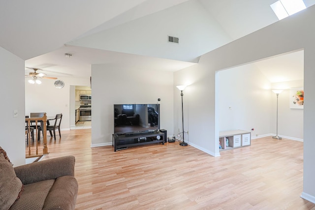 living room featuring vaulted ceiling, ceiling fan, and light hardwood / wood-style floors