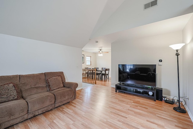 living room with high vaulted ceiling and light hardwood / wood-style floors