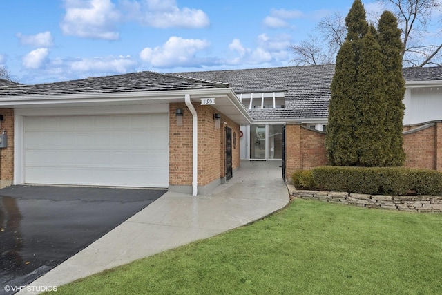 ranch-style house featuring a garage and a front lawn