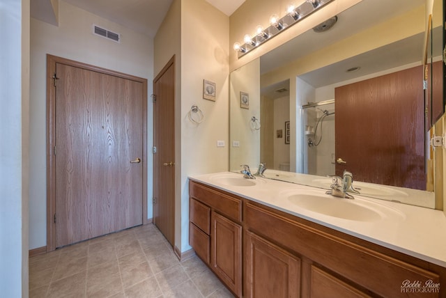 full bath featuring a stall shower, visible vents, a sink, and double vanity