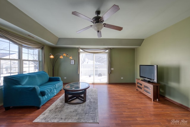 living room featuring wood finished floors, a ceiling fan, and baseboards