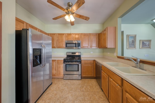 kitchen featuring ceiling fan, appliances with stainless steel finishes, brown cabinets, light countertops, and a sink