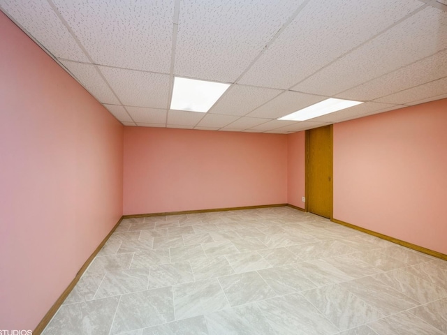 spare room with a drop ceiling and baseboards