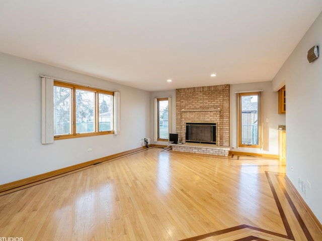 unfurnished living room featuring a fireplace, baseboards, wood finished floors, and recessed lighting