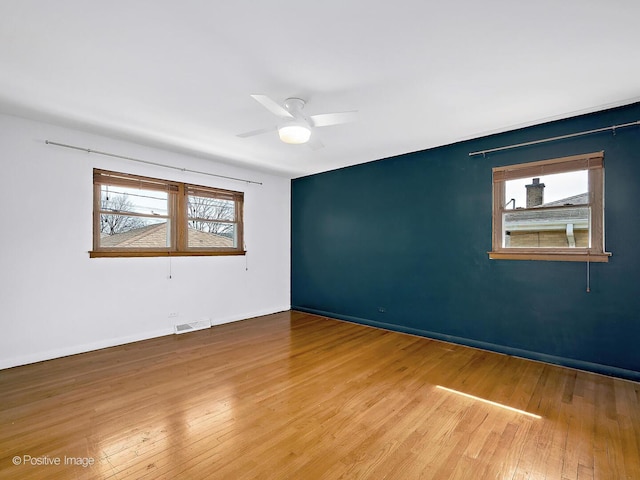 unfurnished room featuring hardwood / wood-style floors, plenty of natural light, and visible vents