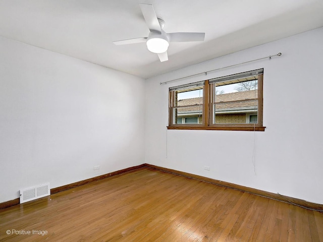 unfurnished room with visible vents, a ceiling fan, baseboards, and wood-type flooring