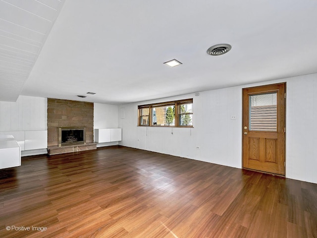 unfurnished living room featuring visible vents, wood finished floors, and a fireplace