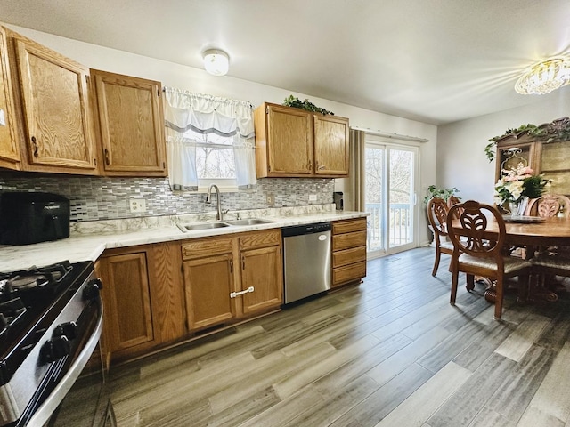 kitchen featuring stainless steel appliances, sink, hardwood / wood-style floors, and backsplash