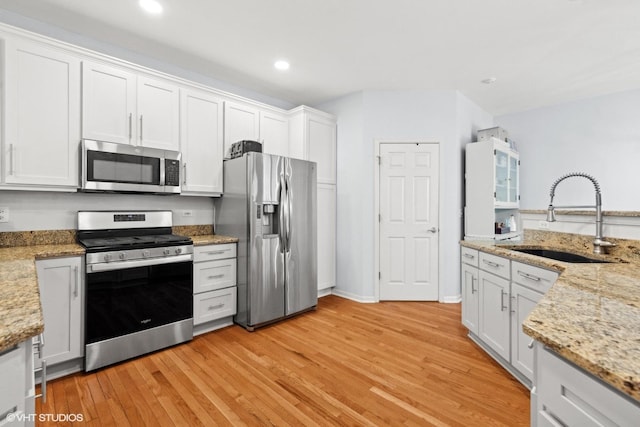 kitchen with white cabinetry, sink, light hardwood / wood-style flooring, and appliances with stainless steel finishes