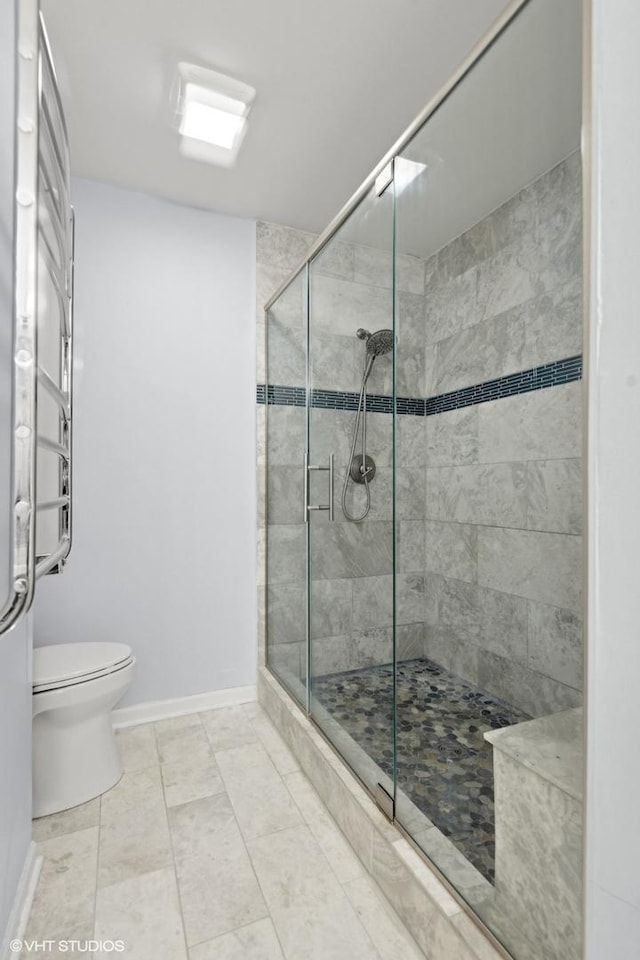 bathroom featuring toilet, tile patterned flooring, and a shower with door